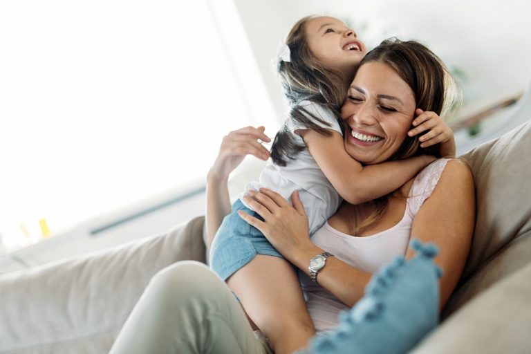Mom and child on a couch hugging
