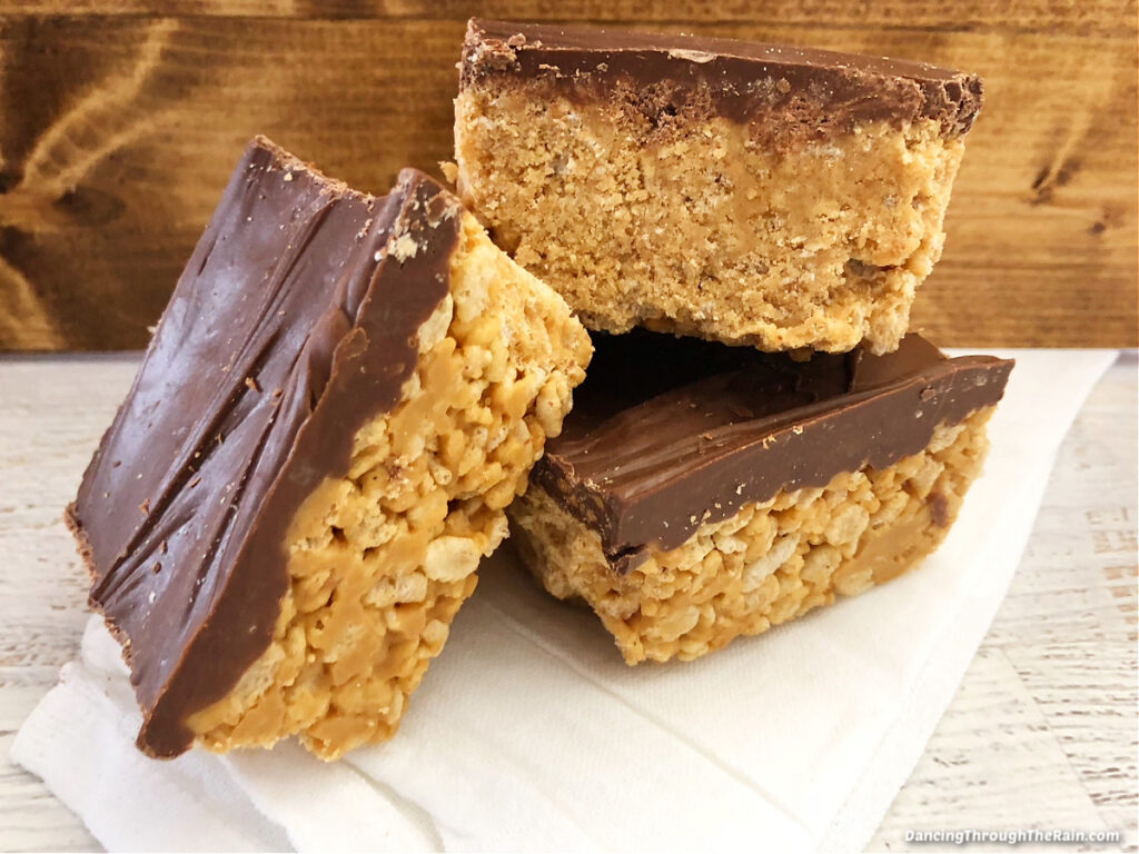 Three Chocolate Scotcharoos on a white fabric napkin on a table