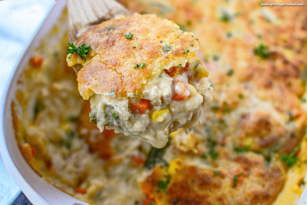 A scoop of Leftover Turkey Biscuit Pot Pie being lifted out of the casserole